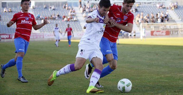 Un jugador del Real Jaén pelea por el balón con otro futbolista de La Roda.