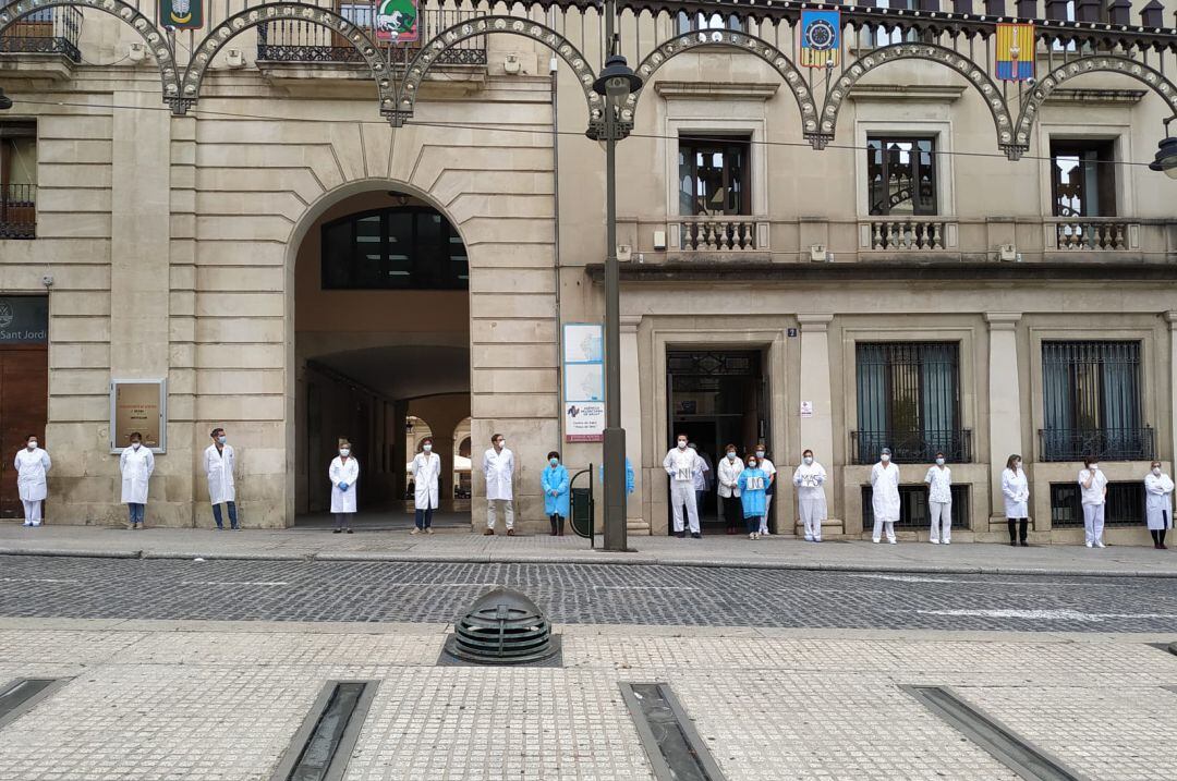 Personal sanitario guardando un minuto de silencio a las puertas del centro de salud de La Plaça para recordar a la TCAE fallecida por coronavirus.