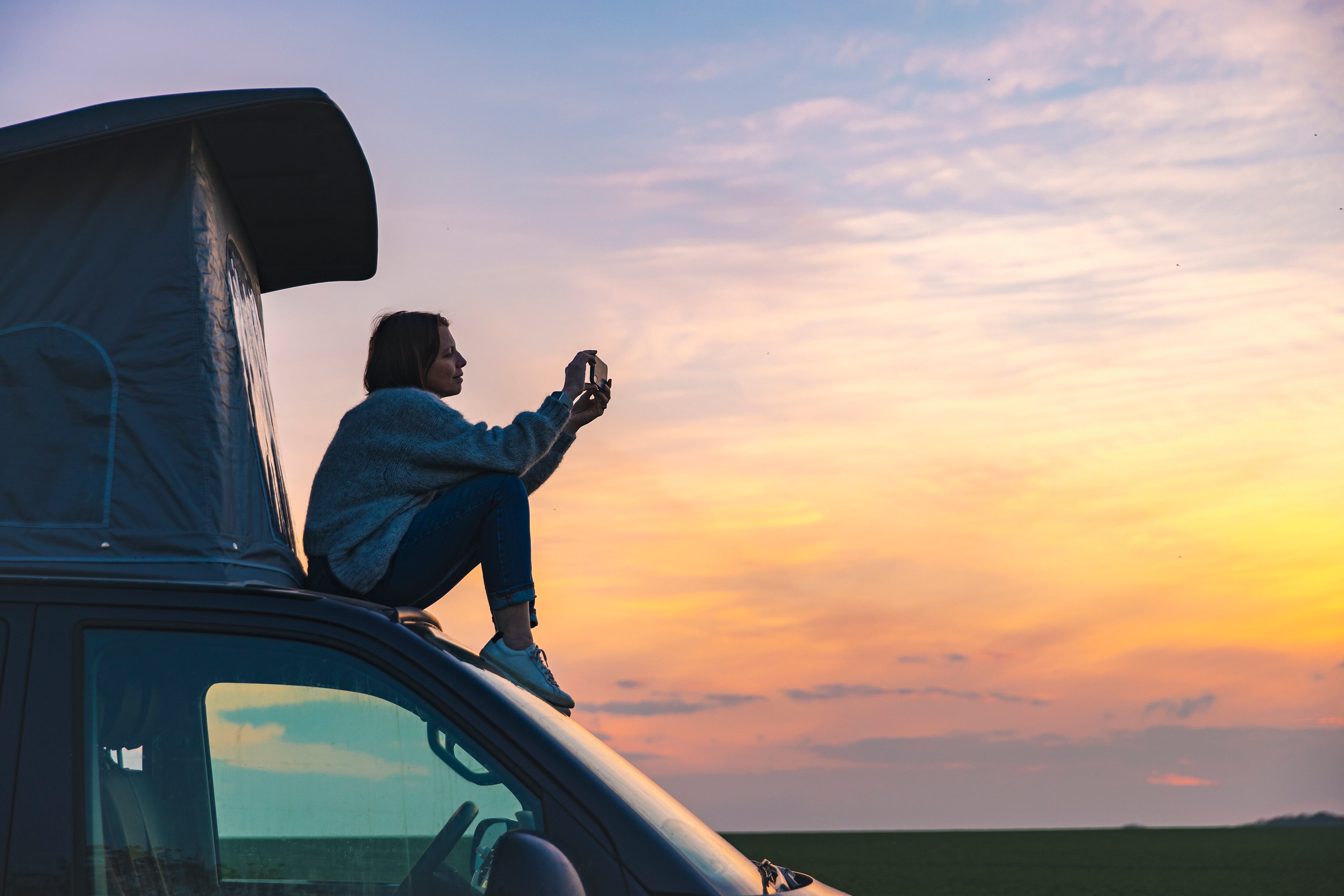 Una mujer sentada en una autocaravana mira el horizonte