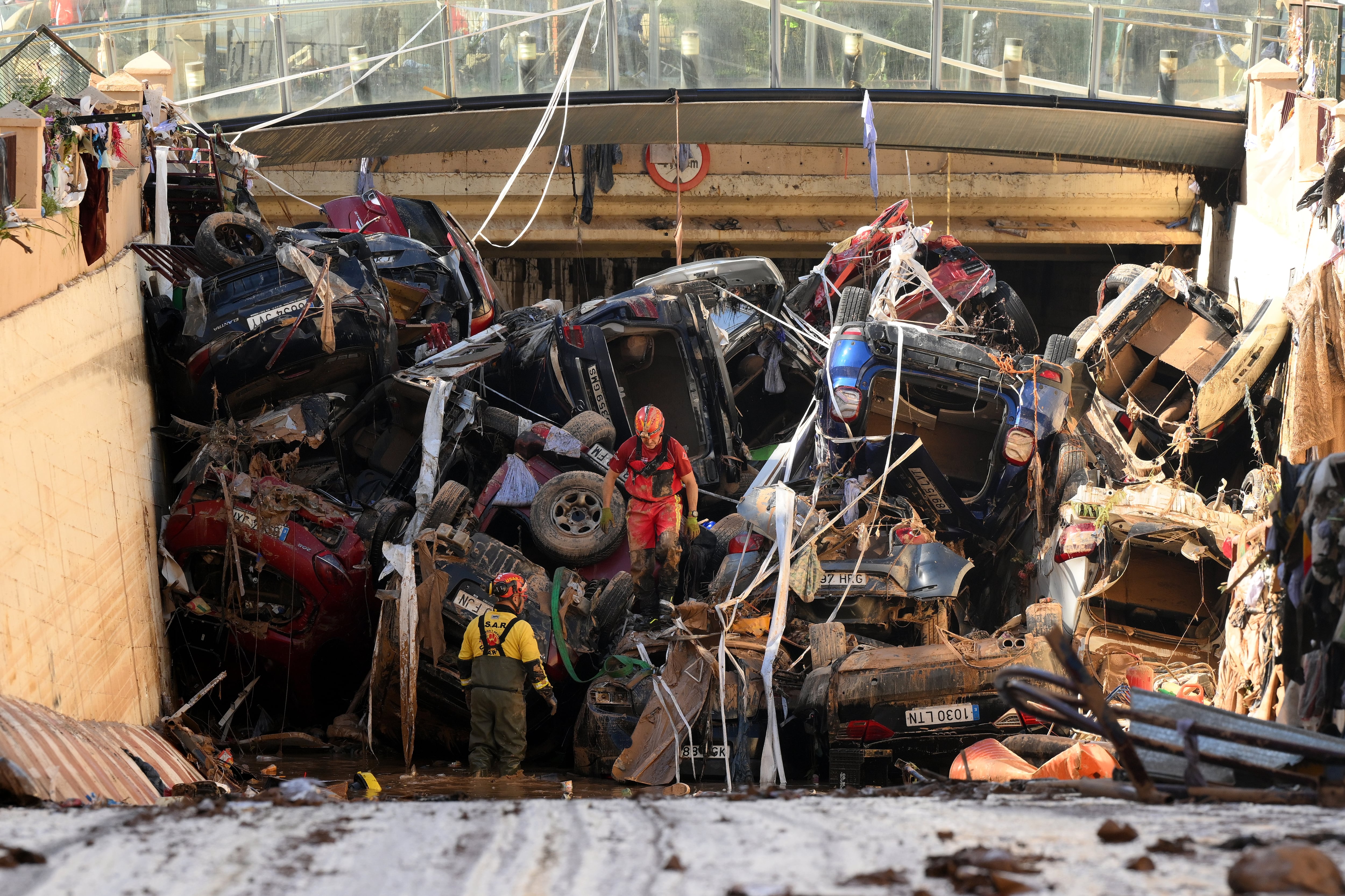 VALENCIA, SPAIN - NOVEMBER 1: Members of the fire brigade, which are part of a search and rescue unit, carry out work as cars and debris block a tunnel on the border of Benetusser and Alfafar municipalities after the recent flash flooding on November 1, 2024 on the border of Benetusser and Alfafar municipalities of Valencia, Spain. By Friday morning, Spanish authorities confirmed that at least 200 people had died, mostly in the Valencia region, amid the flooding that swept eastern and southern parts of the country starting on Tuesday. The intense rainfall event is known as a &quot;cold drop&quot; or DANA weather system. (Photo by David Ramos/Getty Images)