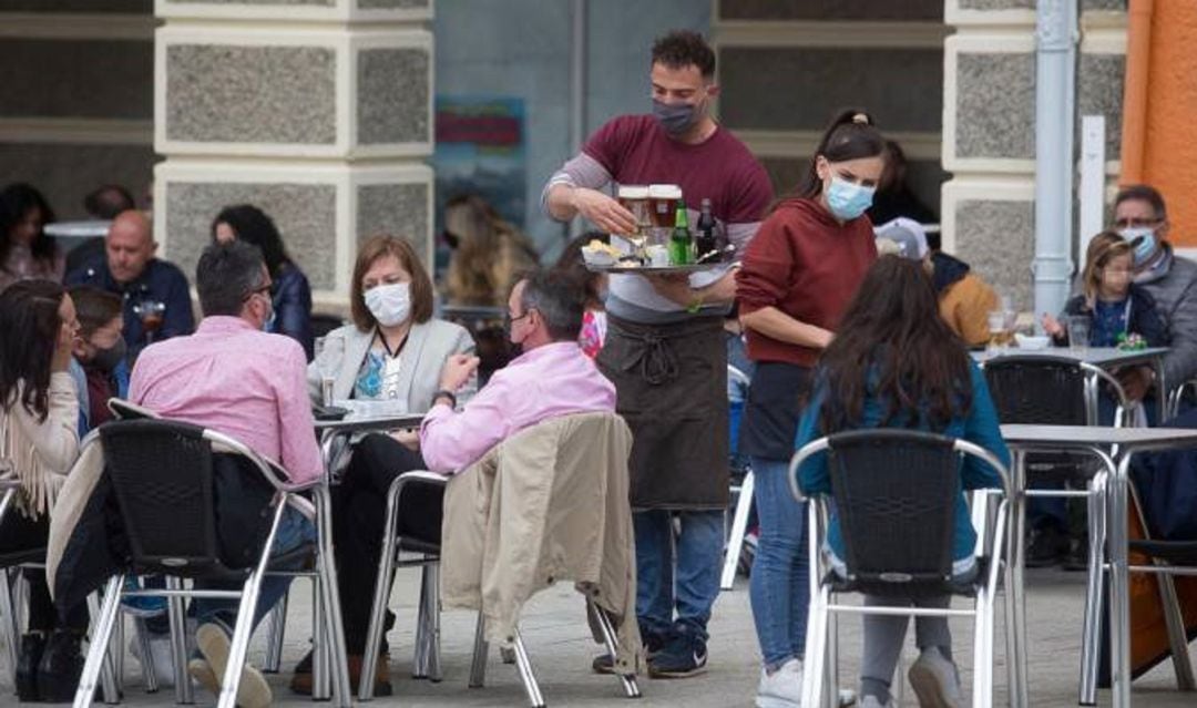 Varias personas tomando un refresco en un bar.