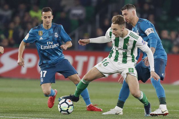 Morón (c) lucha el balón con Sergio Ramos (d), del Real Madrid, durante el partido de Liga en Primera División, correspondiente a la vigésimo cuarta jornada, que se disputa hoy en el Benito Villamarín, en Sevilla.