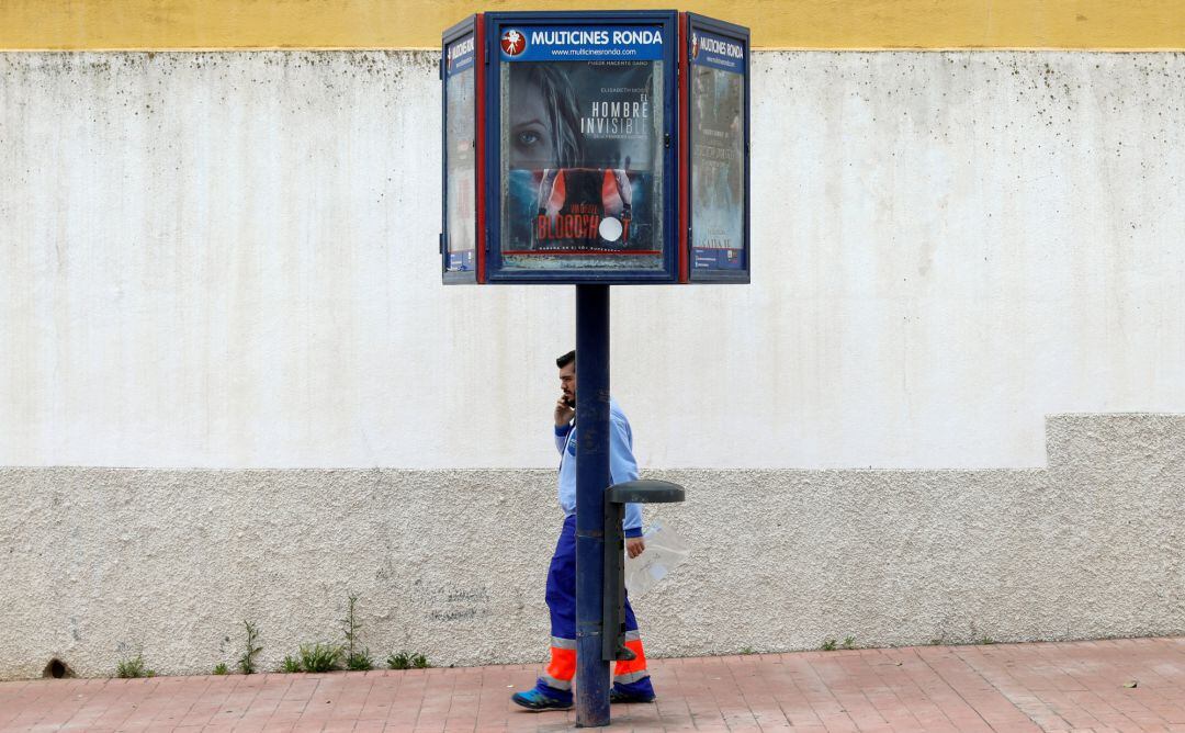 Un sanitario camina bajo el cartel de la película &#039;El Hombre Invisible&#039;