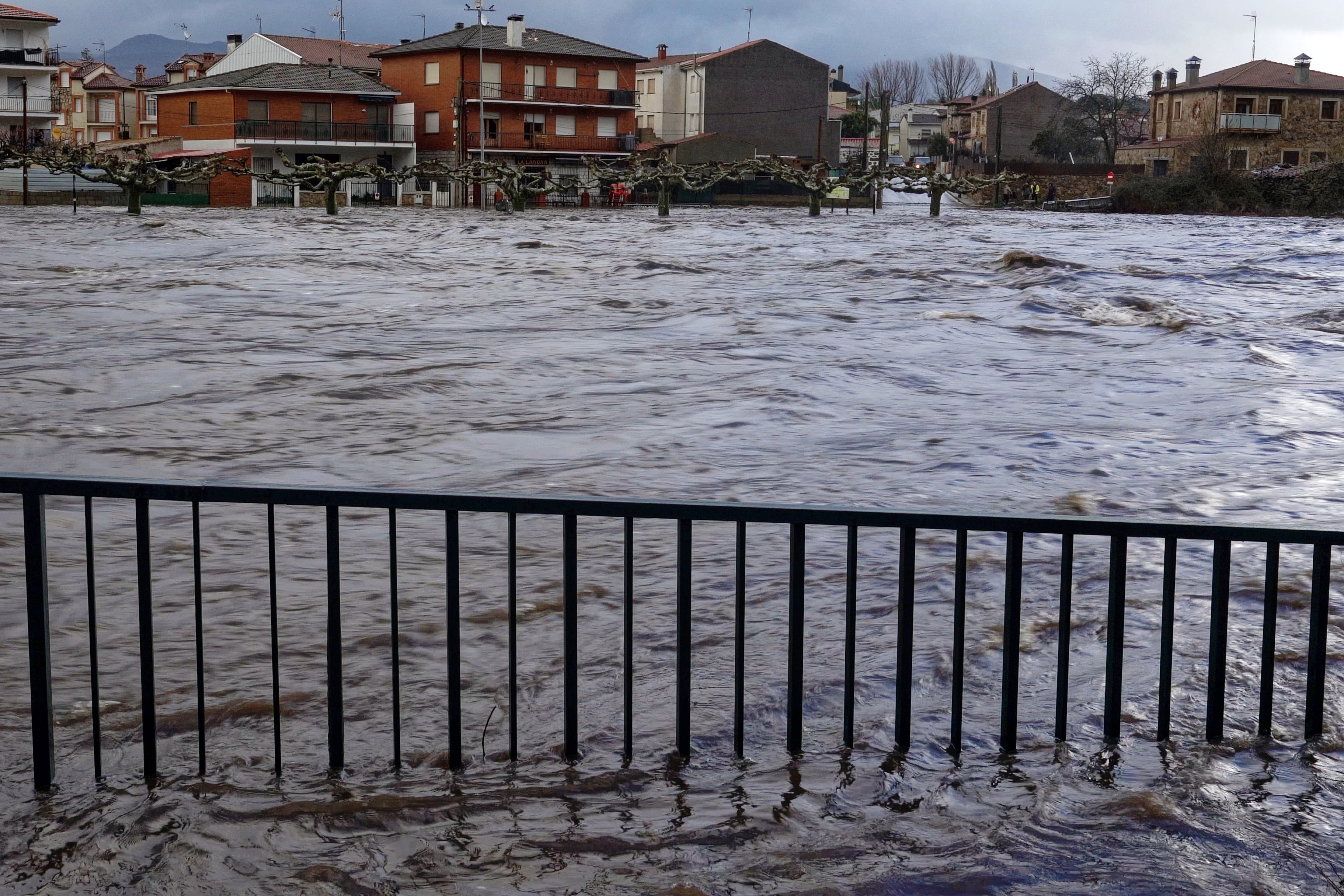 Vista del Río Alberche, desbordado a su paso por la localidad abulense de Navaluenga por el temporal de la borrasca Jana este sábado