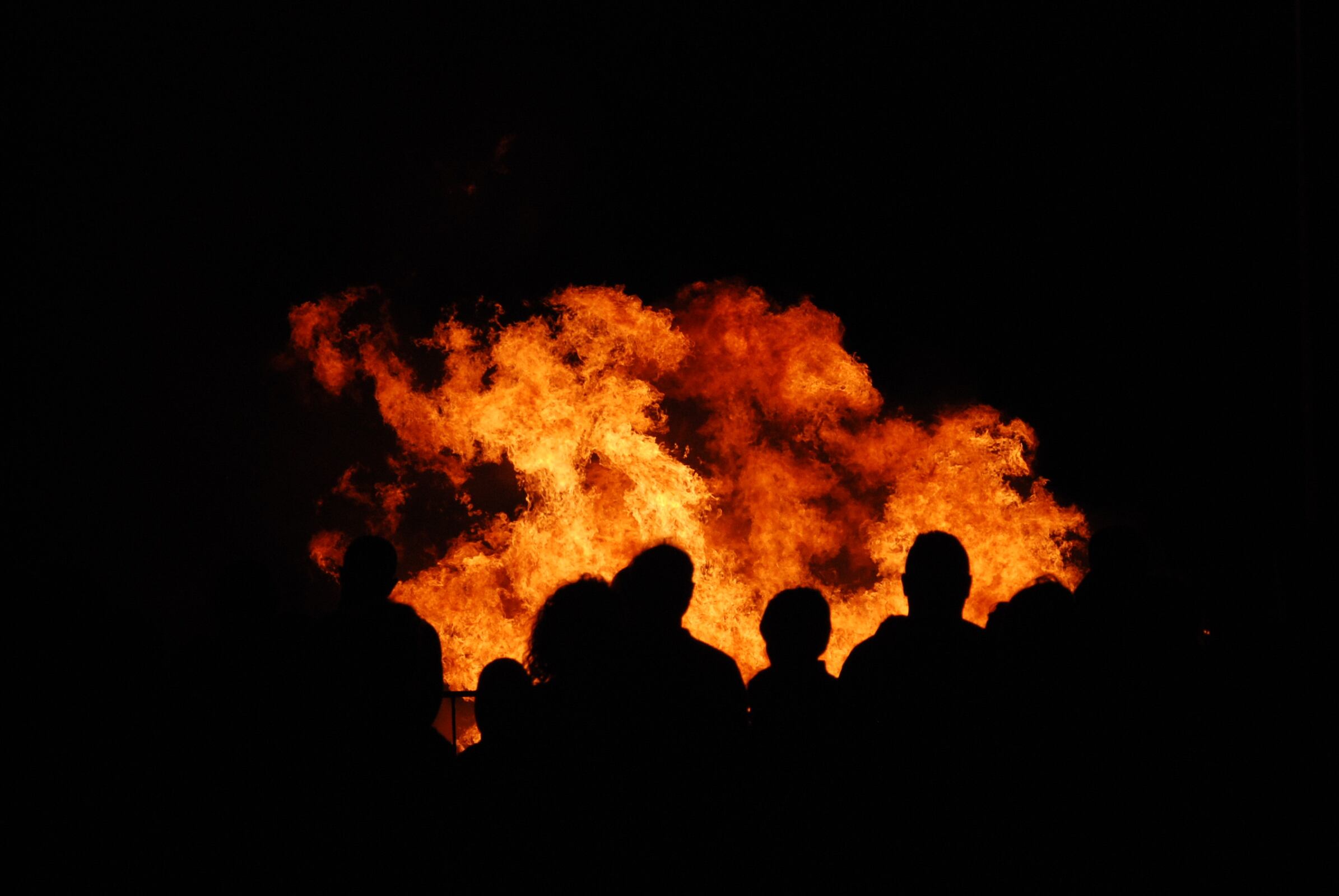 Personas observando el fuego de una hoguera