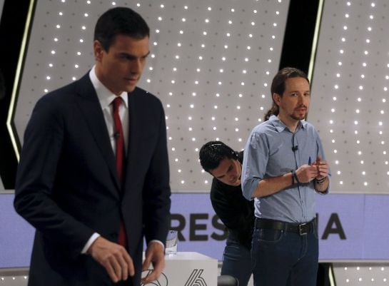 Podemos (We Can) party leader Pablo Iglesias (R) has his microphone adjusted by a technician as Socialist party (PSOE) leader Pedro Sanchez stands before a live debate hosted by Spanish media group Atresmedia in San Sebastian de los Reyes, near Madrid, Sp