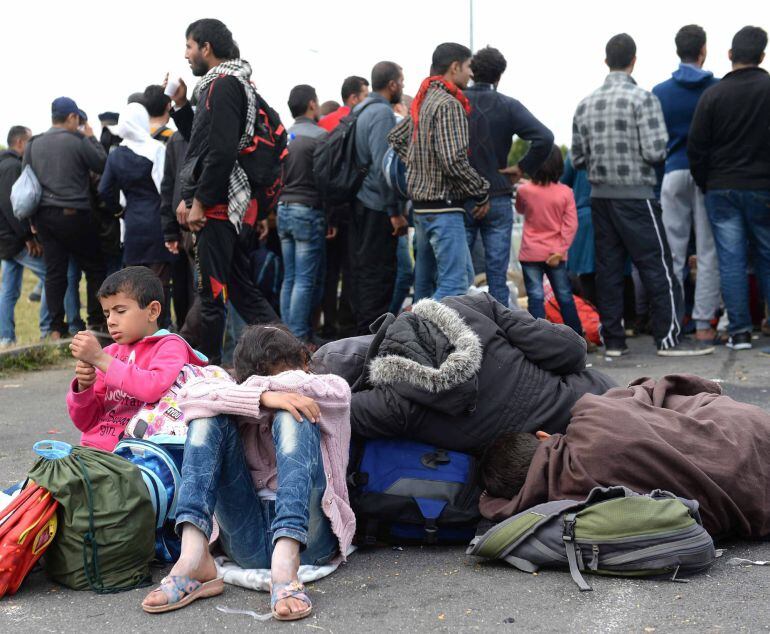 MTI125 HEILIGENKREUZ (AUSTRIA) 13/09/2015.- Refugiados descansan en la frontera entre Hungría y Austria, en Heiligenkreuz (Austria), hoy, 14 de septiembre de 2015. Austria desplegará a su ejército en la frontera con Hungría para ayudar la policía en los controles fronterizo, según manifestó hoy ante los medios el canciller federal austríaco, Werner Faymann. EFE/ROLAND SCHLAGER
