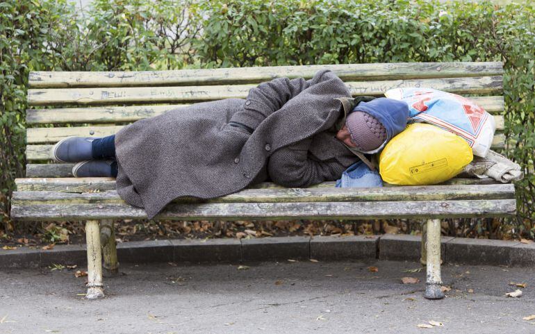 Una persona durmiendo en un banco