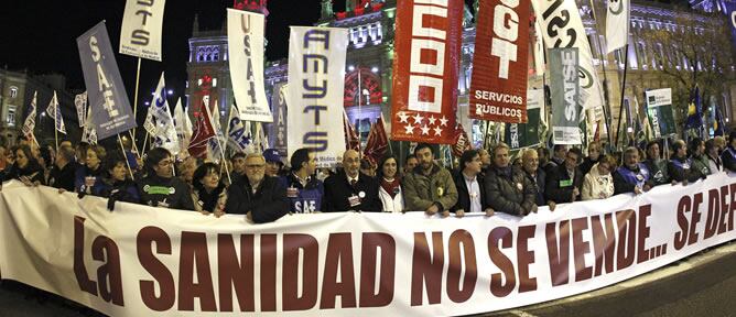 Pancarta con el lema &quot;La sanidad no se vende. Se defiende&quot; que gran número de personas sostienen a su paso por la plaza de Cibeles