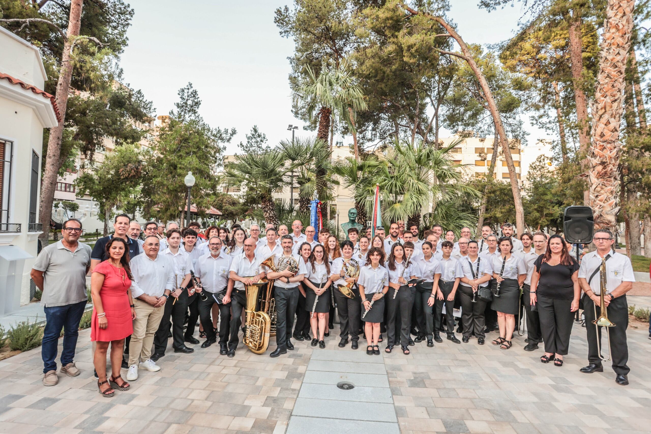 Los miembros de la AMCE Santa Cecilia posan junto al busto de Ramón Gorgé