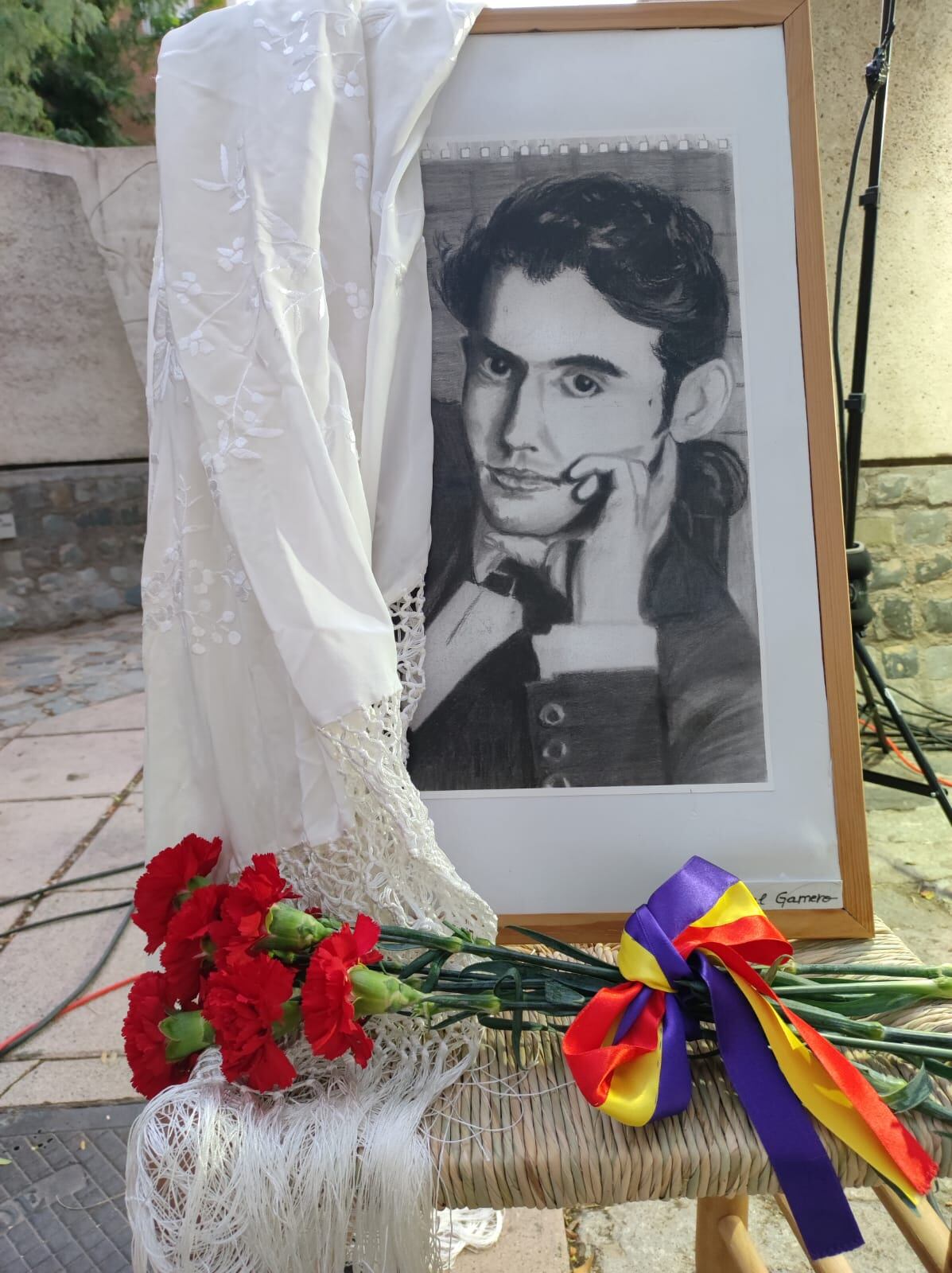 Retrato de Federico García Lorca colocado frente al monumento dedicado al poeta de Villa de Vallecas, Paseo Federico García Lorca, en el acto de 2023