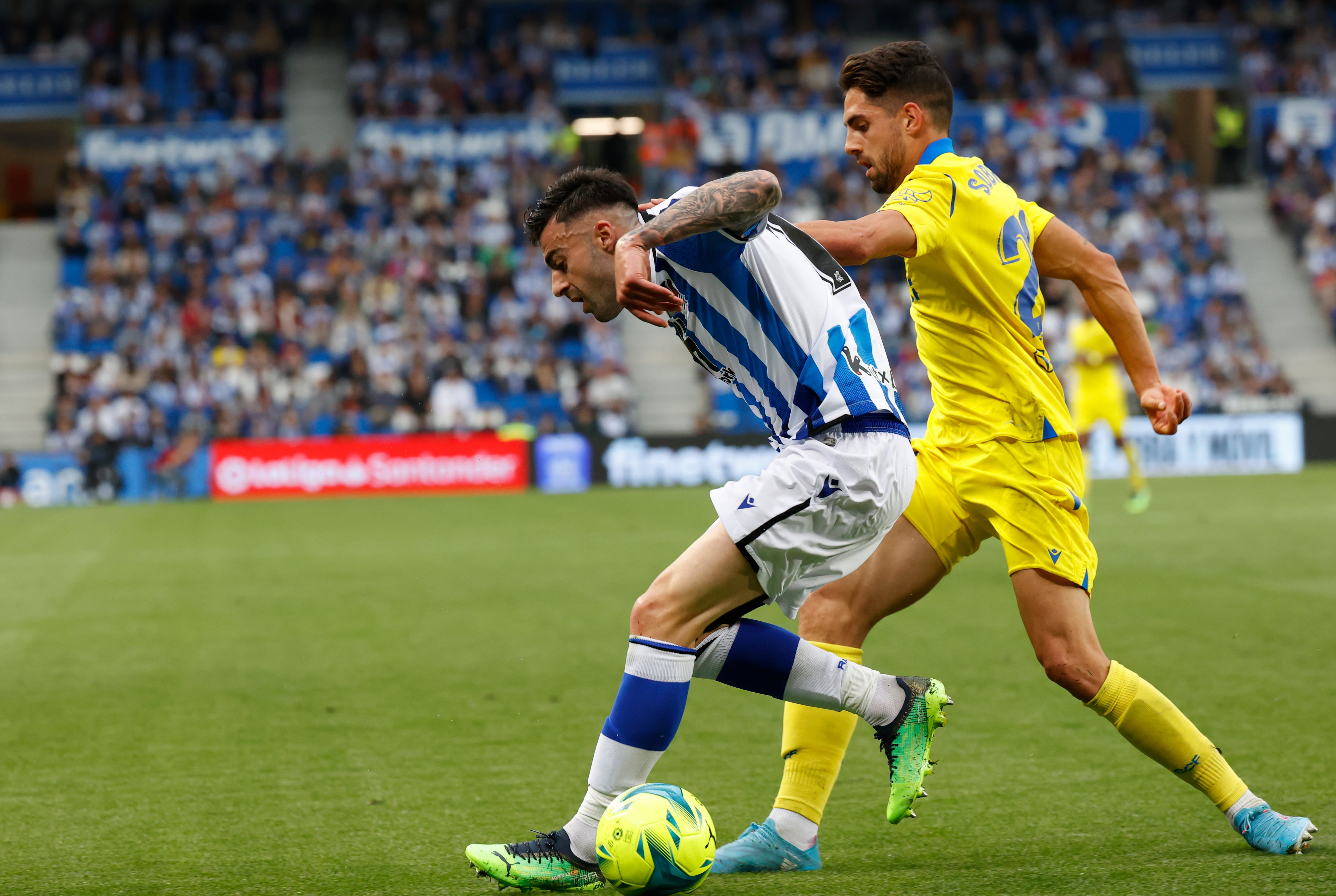 SAN SEBASTIÁN, 12/05/2022.- El defensa de la Real Sociedad Diego Rico (i) controla la pelota ante el centrocampista del Cádiz CF, Rubén Sobrino (d), durante el partido de la jornada 36 de Liga en Primera División que se disputa hoy jueves en el Reale Arena, en San Sebastián. EFE/Javier Etxezarreta