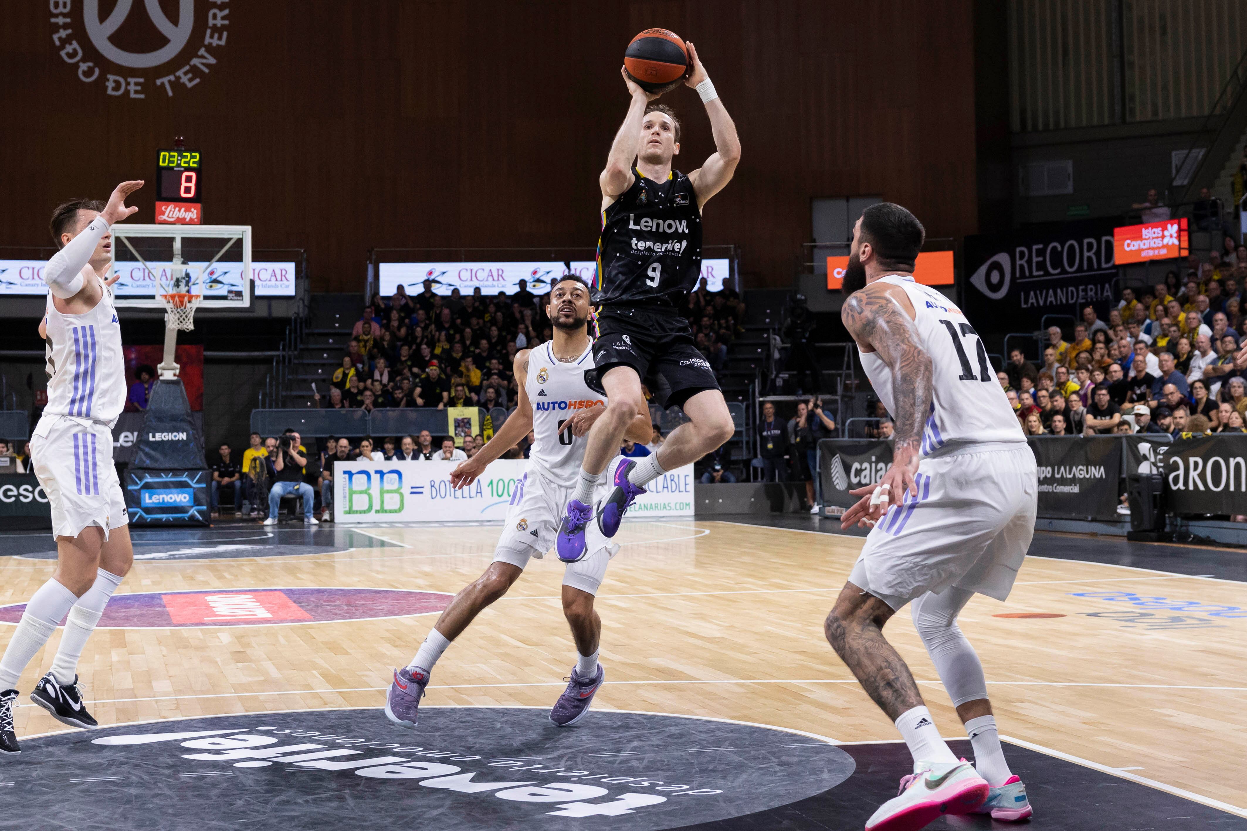 LA LANGUNA (TENERIFE), 18/12/2022.- El base brasileño del Lenovo Tenerife Marcelinho Huertas (c) tira a canasta ante la presencia de los jugadores del Real Madrid, durante el partido de la jornada 12 de la Liga Endesa que disputan Lenovo Tenerife y Real Madrid, este domingo en el pabellón Santiago Martín, en La Laguna, Tenerife. EFE/ Miguel Barreto