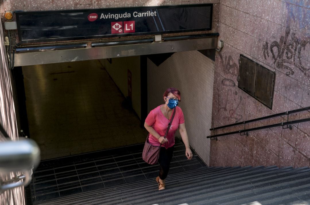 Una mujer con mascarilla saliendo del metro en Barcelona.