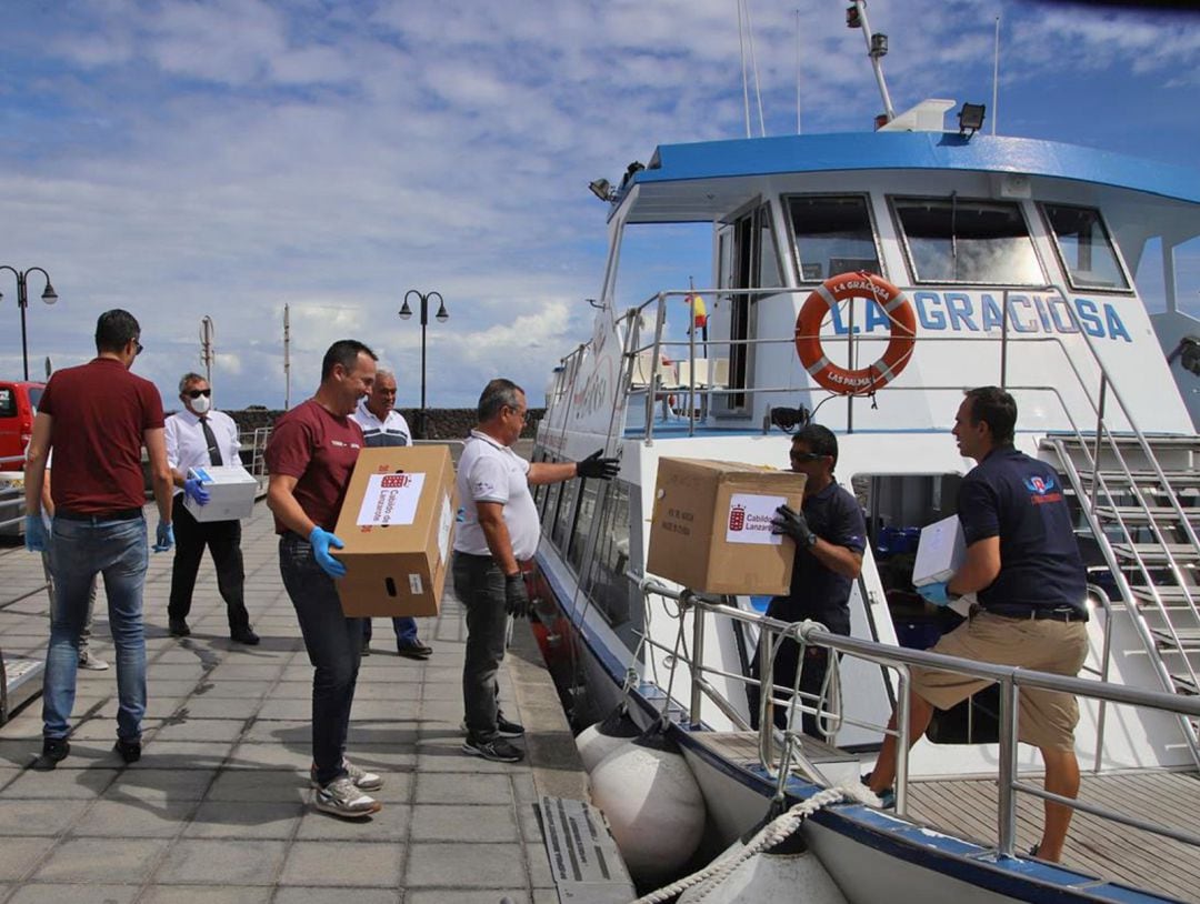 Efectivos del Consorcio de Seguridad y Emergencias de Lanzarote entregando material de protección a Líneas Romero para transportarlas a La Graciosa.