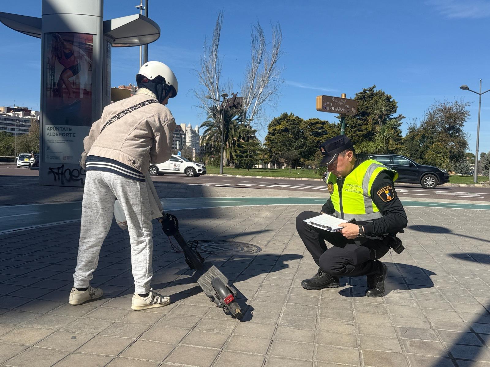 Policía Local inspeccionando un patinete eléctrico.