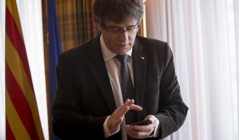 Puigdemont consultando su teléfono móvil.