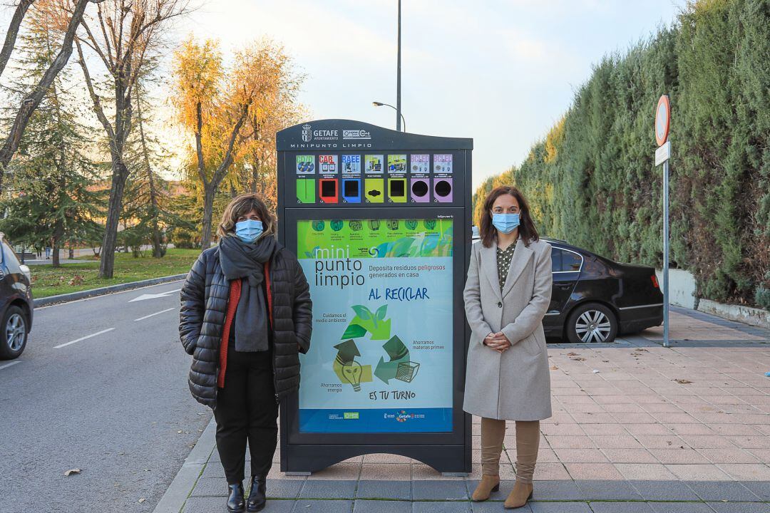 Sara Hernández, alcaldesa, (d) y Maite Mellado, concejala Delegada de Mantenimiento y Limpieza, junto a uno de los puntos limpios instalados en el municipio.