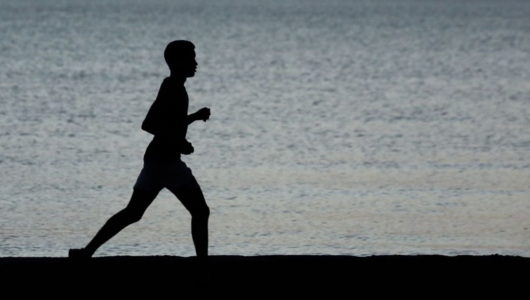 Una persona practica deporte en la playa (imagen de archivo).