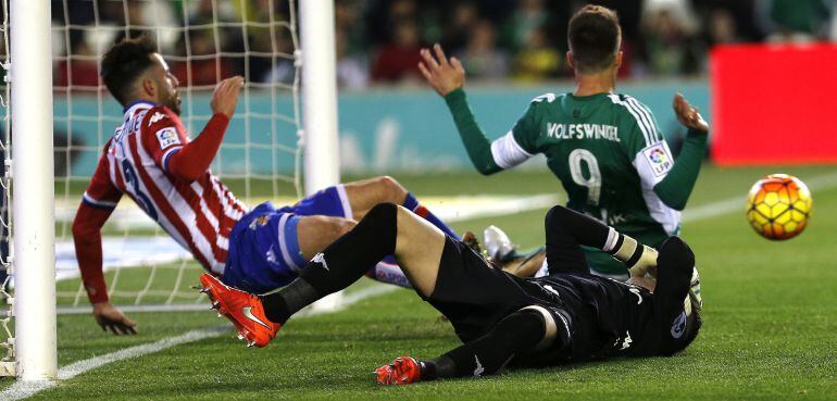 Los jugadores del Sporting Álex Menéndez e Iván Cuéllar disputan el balón con el delantero holandés del Betis Ricky van Wolfswinkel.