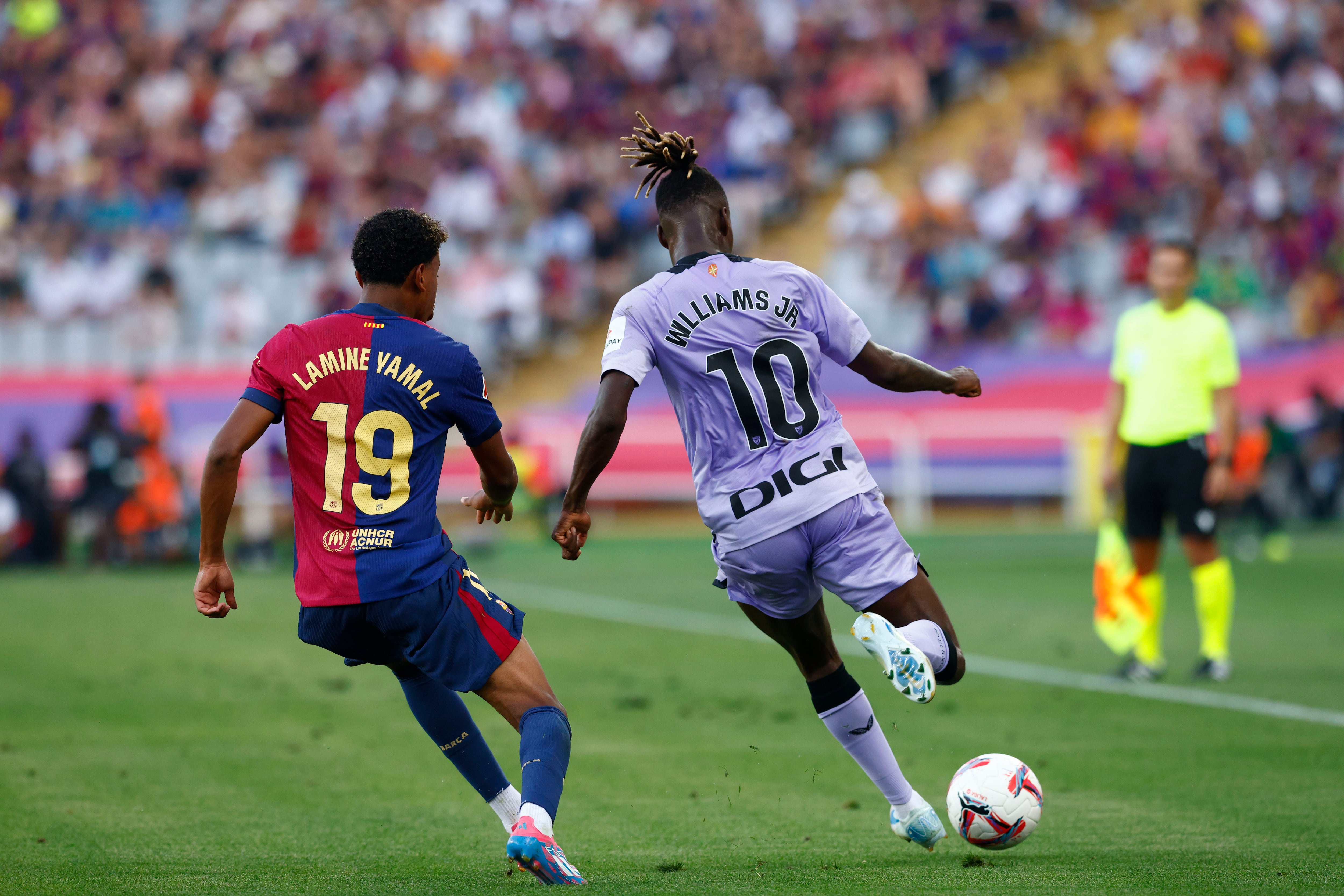 El delantero del Athletic Nico Williams (d) juega un balón ante Lamine Yamal, del Barcelona, durante el partido de Liga en Primera División que FC Barcelona y Athletic Club disputan este sábado en el Estadio Olímpico Lluis Companys