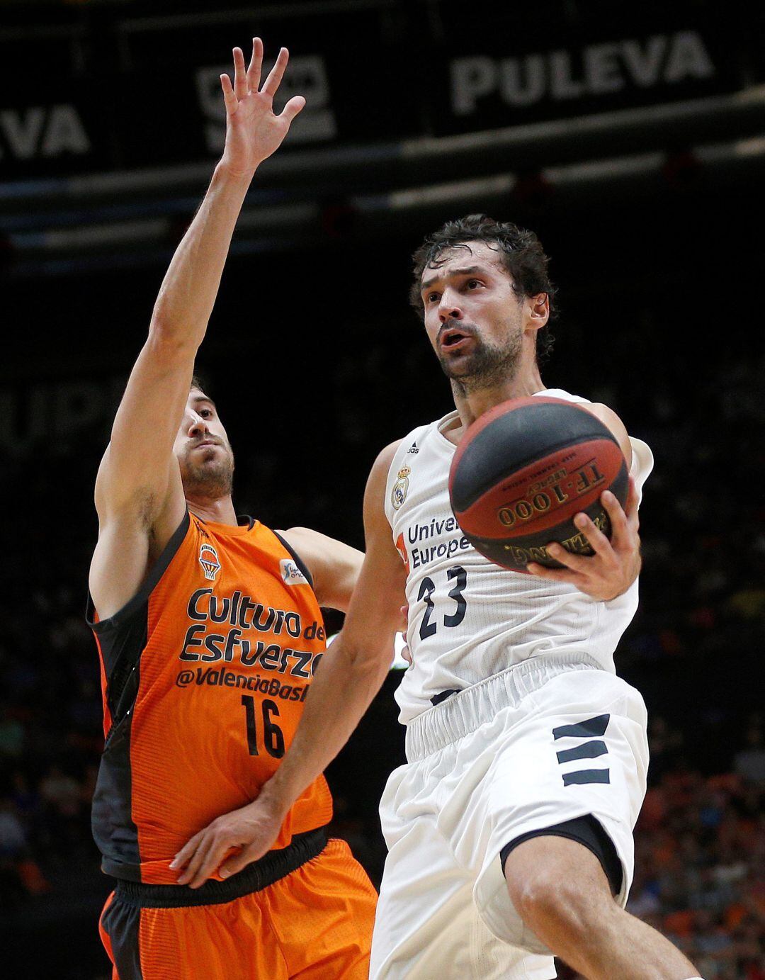 El base del Real Madrid Sergio Llull (d) entra a canasta defendido por Guillem Vives, del Valencia Basket, en el partido de la segunda jornada de liga ACB que se disputa esta noche en el pabellón de la Fuente de San Luis. 