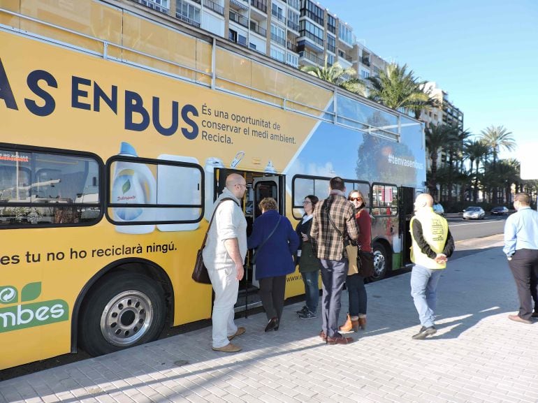 Viajeros subiendo al autobús para concienciar sobre el reciclaje en Dénia.