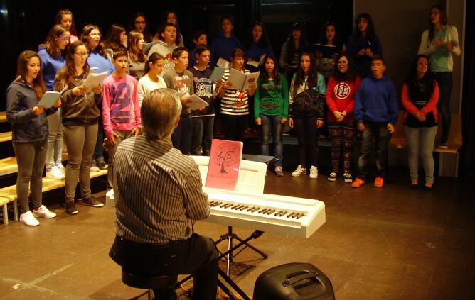 El director y compositor Julio Domínguez dirige a un grupo de alumnos de secundaria durante un ensayo coral