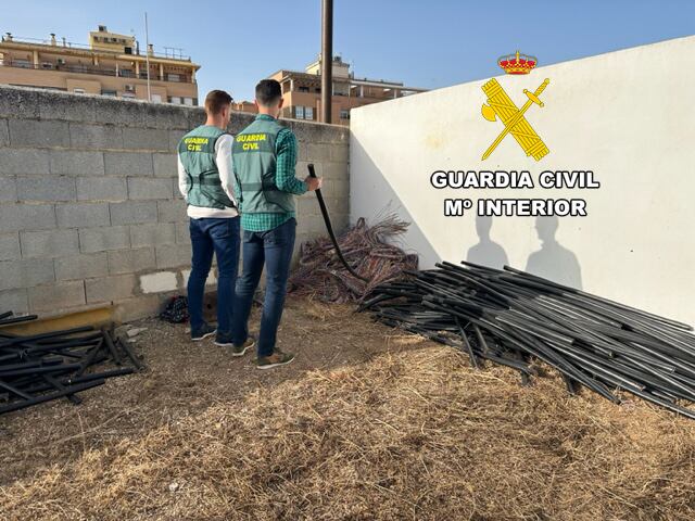 Dos agentes de la Guardia Civil comprueban los cables incautados en Andújar.