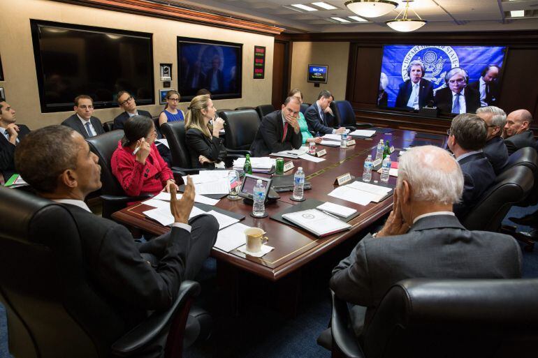 Fotografía cedida por la Casa Blanca que muestra al presidente estadounidense, Barack Obama (i), y a su vicepresidente, Joe Biden (d), rodeados de su equipo de seguridad nacional, mientras participan en una teleconferencia desde la Casa Blanca