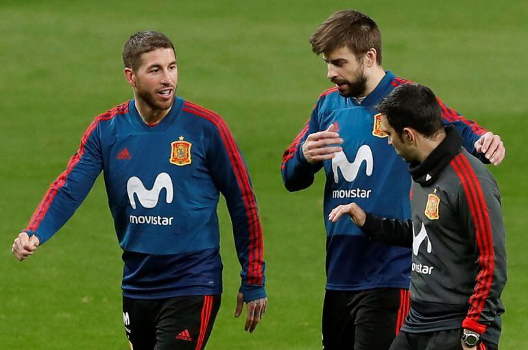 Los jugadores de la selección española Gerard Piqué (c) y Sergio Ramos (i) durante el entrenamiento llevado a cabo hoy en el estadio Wanda Metropolitano de Madrid