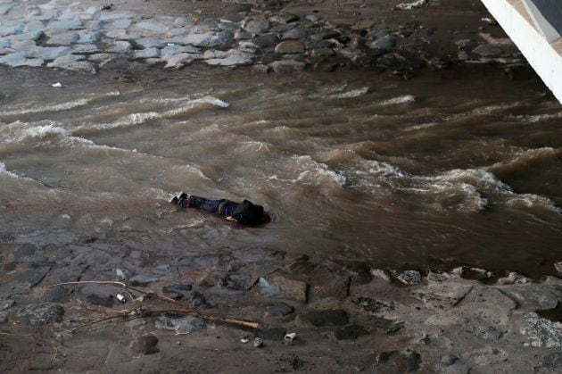 Un manifestante yace en el río después de caer de un puente durante una protesta contra el gobierno de Chile, en Santiago, Chile.