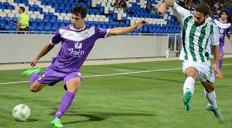 Un jugador del filial cordobés intenta quitar la pelota a un jugador jienense durante el partido