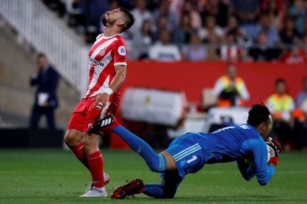 El guardameta costarricense del Real Madrid, Keylor Navas, captura el balón ante el delantero del Girona, Cristian Portugués &quot;Portu&quot;, durante el encuentro correspondiente a la segunda jornada de primera división que disputan esta noche en el estadio Municipal Montilivi, en la capital gerundense.