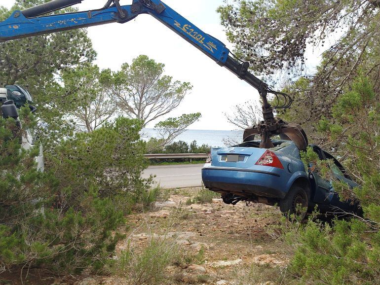 Una grúa retirando uno de los vehículos abandonados