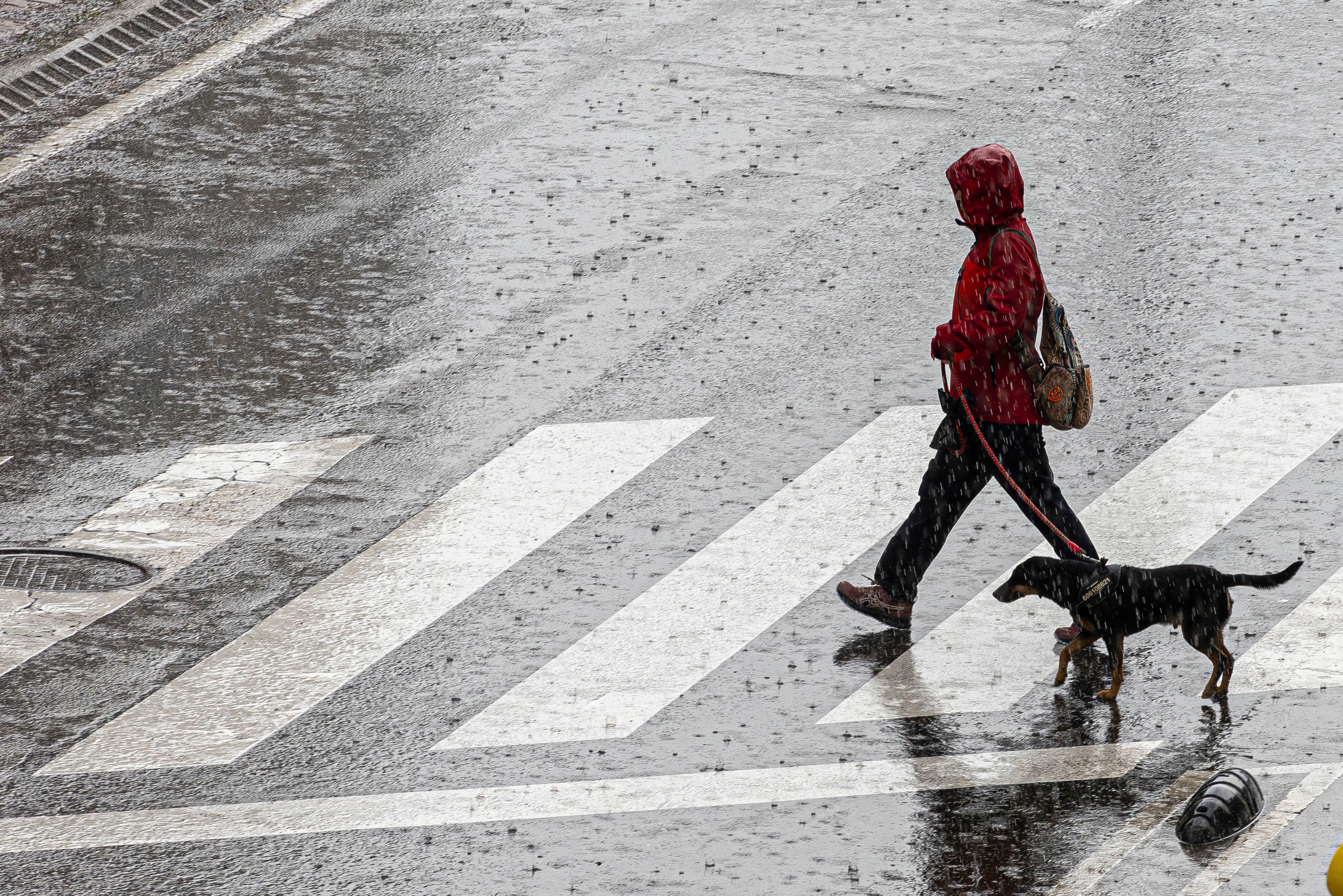 Una mujer cruza una calle durante una tormenta