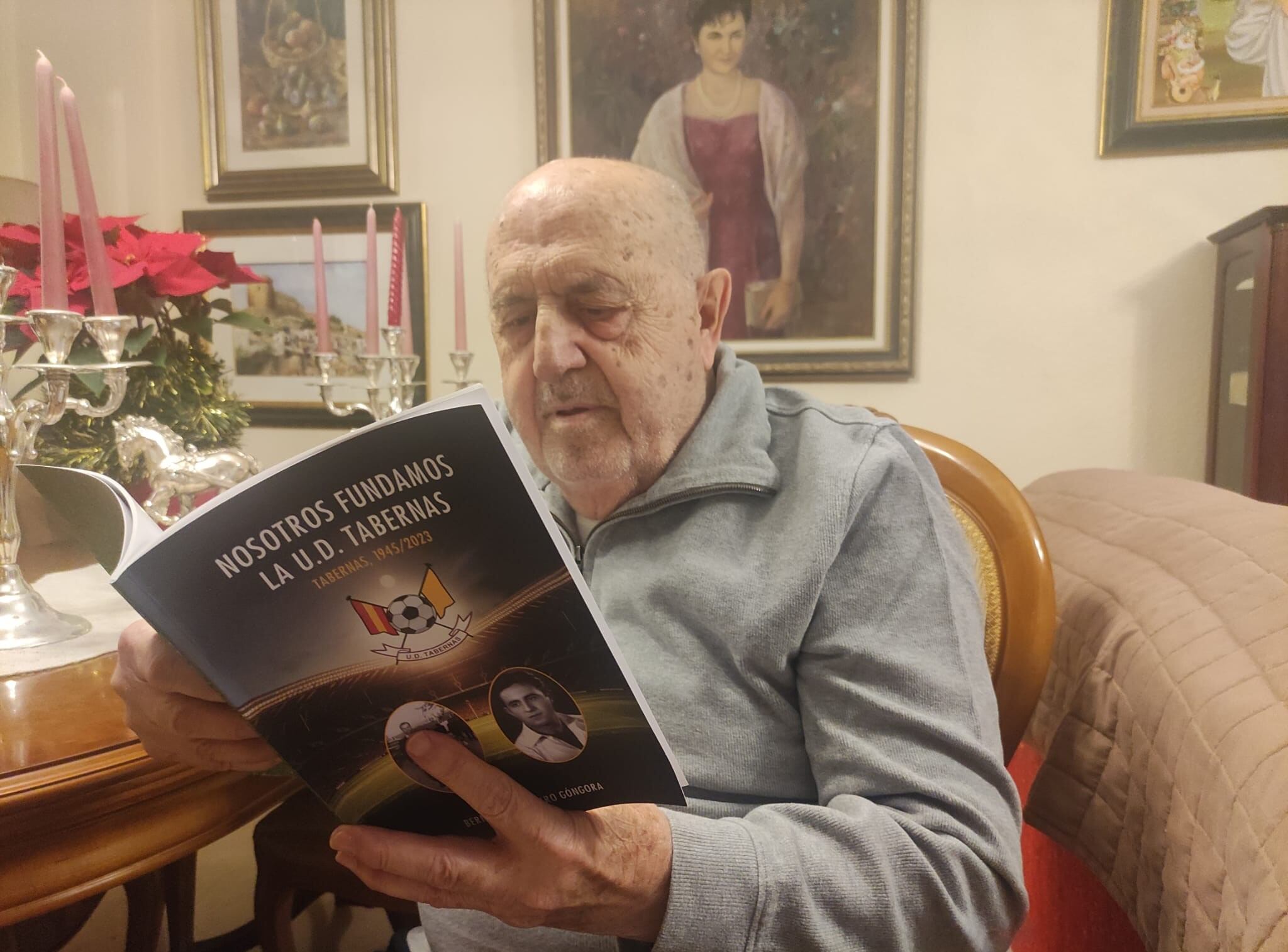 Bernabé Navarro leyendo su fantástico libro en el salón de su casa.