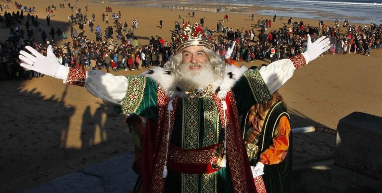 El rey Melchor, saluda los niños tras descender del helicoptero que les transporto hasta la playa de San Lorenzo de Gijon
