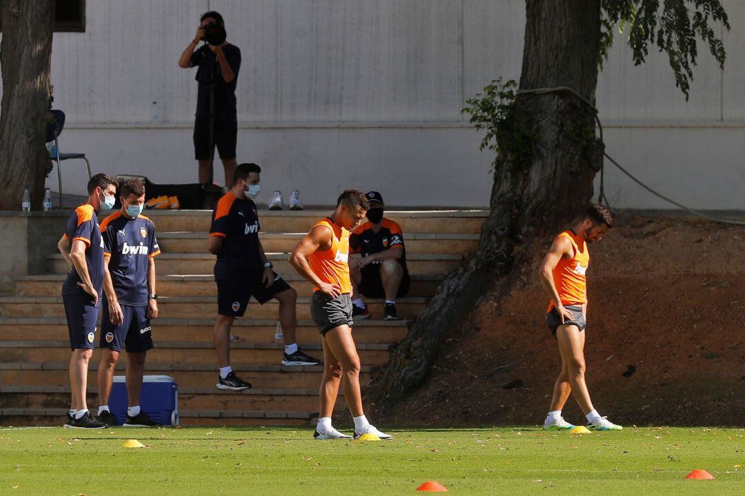 GRAFCVA7324. PATERNA (VALENCIA), El técnico del Valencia CF, Javi Gracia (izqda), observa a Rodrigo Moreno (centro), y a José Luis Gayá, que han entrenado al margen del resto de sus compañeros, esta mañana en la Ciudad deportiva del club en Paterna. EFE, Manuel Bruque