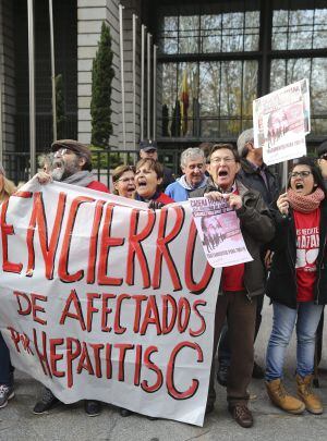 GRA037. MADRID, 27/12/2014.- Varias personas participan en una cadena humana, organizada por la Plataforma de Afectados por la Hepatitis C, rodeando el Ministerio de Sanidad para exigir tratamientos para la enfermedad.- EFE/Ballesteros