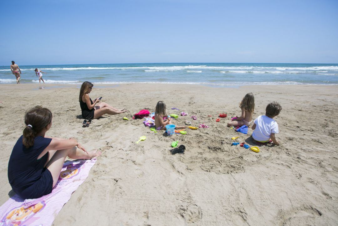 Una familia en la arena playa de Gandia en la fase 2