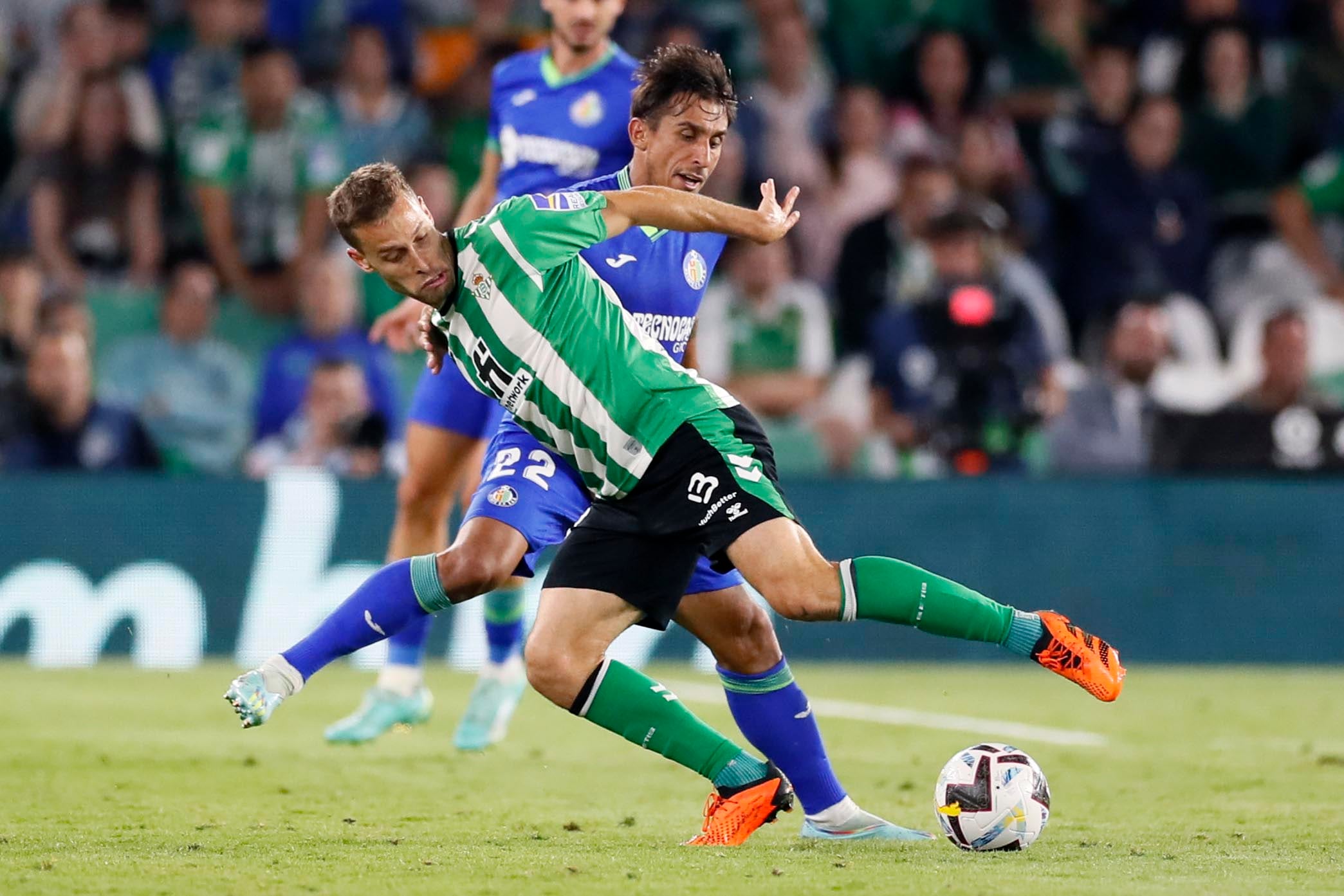 El centrocampista del Betis, Sergio Canales, disputa el balón ante el defensa uruguayo del Getafe, Damián Suárez, durante el encuentro correspondiente a la jornada 36 de Primera División que disputan hoy miércoles en el estadio Benito Villamarín, en Sevilla. EFE/José Manuel Vidal