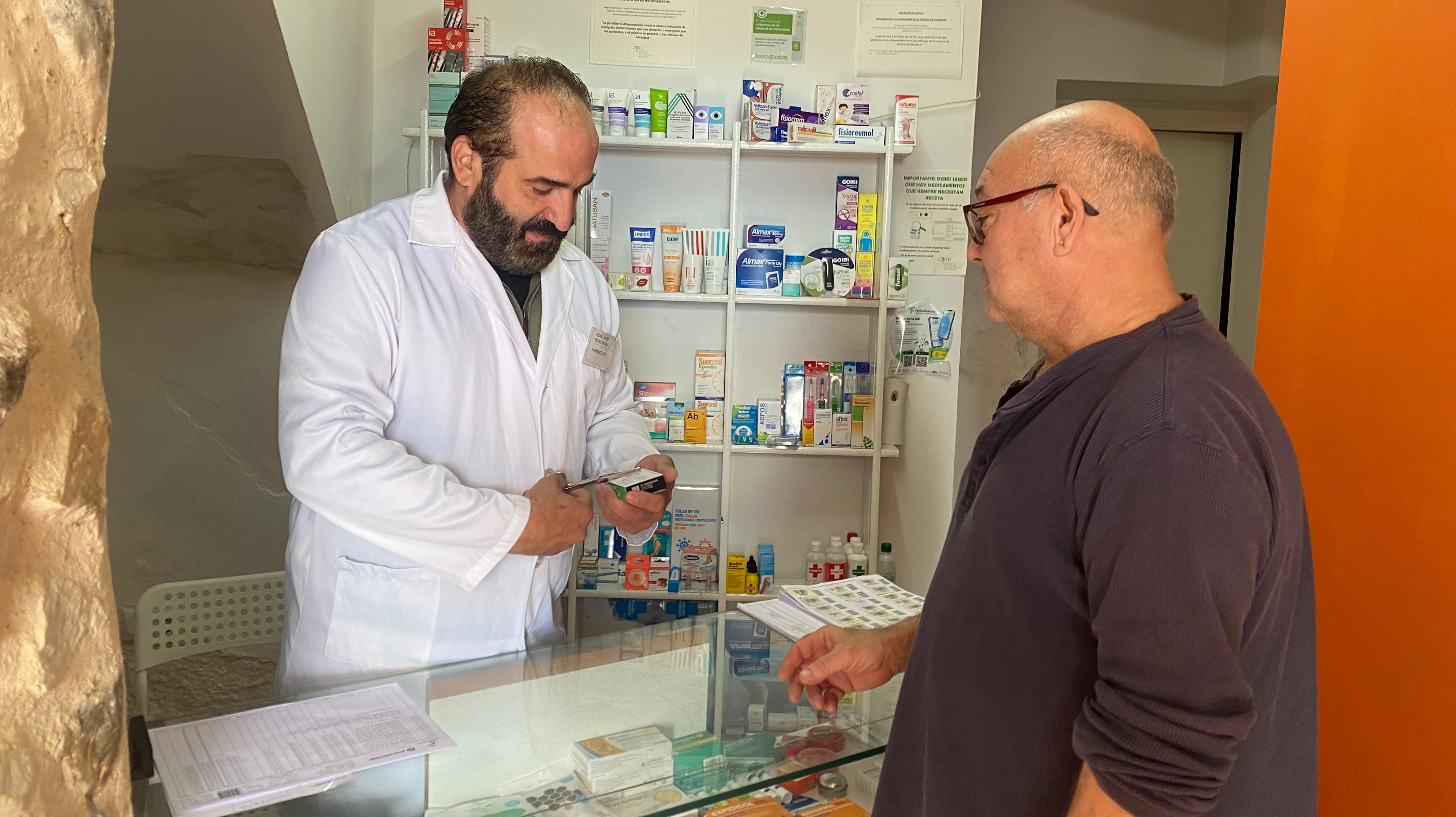 Pedro Alejo Pérez Rueda, farmacéutico regente de Las Majadas (Cuenca), atiende a Goyo, uno de sus vecinos.