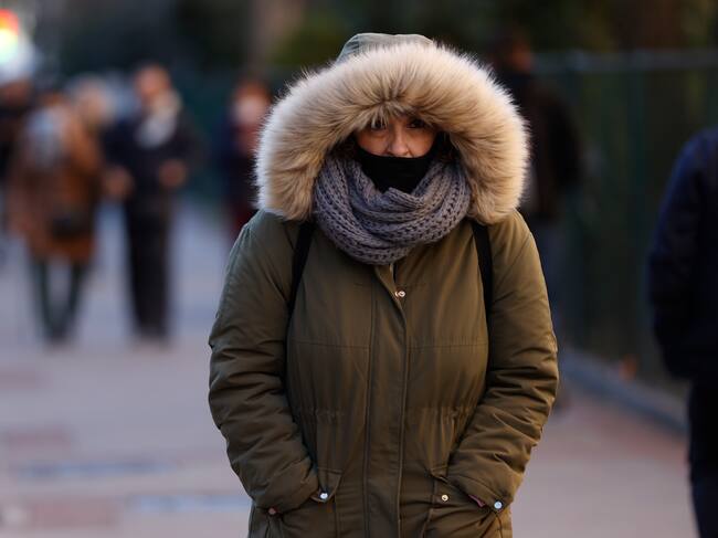 Una mujer pasea por protegida con una bufanda