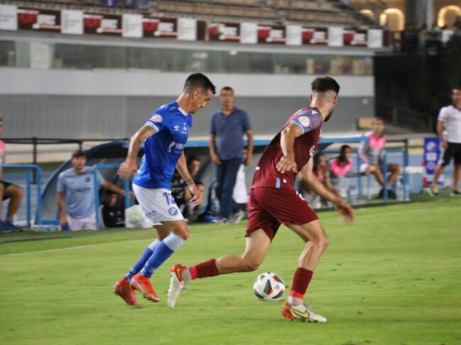 Bello conduciendo un balón ante un rival