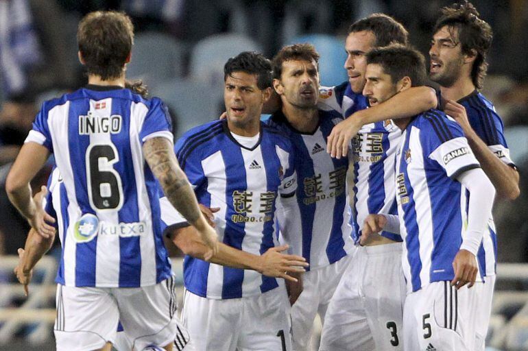 GRA399. SAN SEBASTIÁN, 09/11/2014.- Los jugadores de la Real Sociedad felicitan al mexicano Carlos Vela (2-i) tras marcar ante el Atlético de Madrid, durante el partido de Liga en Primera División que disputan esta noche en el estadio de Anoeta, en San Se