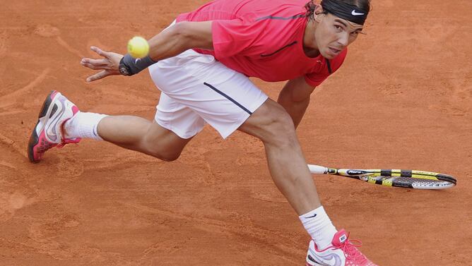 El tenista español Rafael Nadal devuelve la pelota al argentino Juan Mónaco durante el partido correspondiente a los octavos de final de Roland Garros disputado en París, Francia hoy 4 de junio de 2012