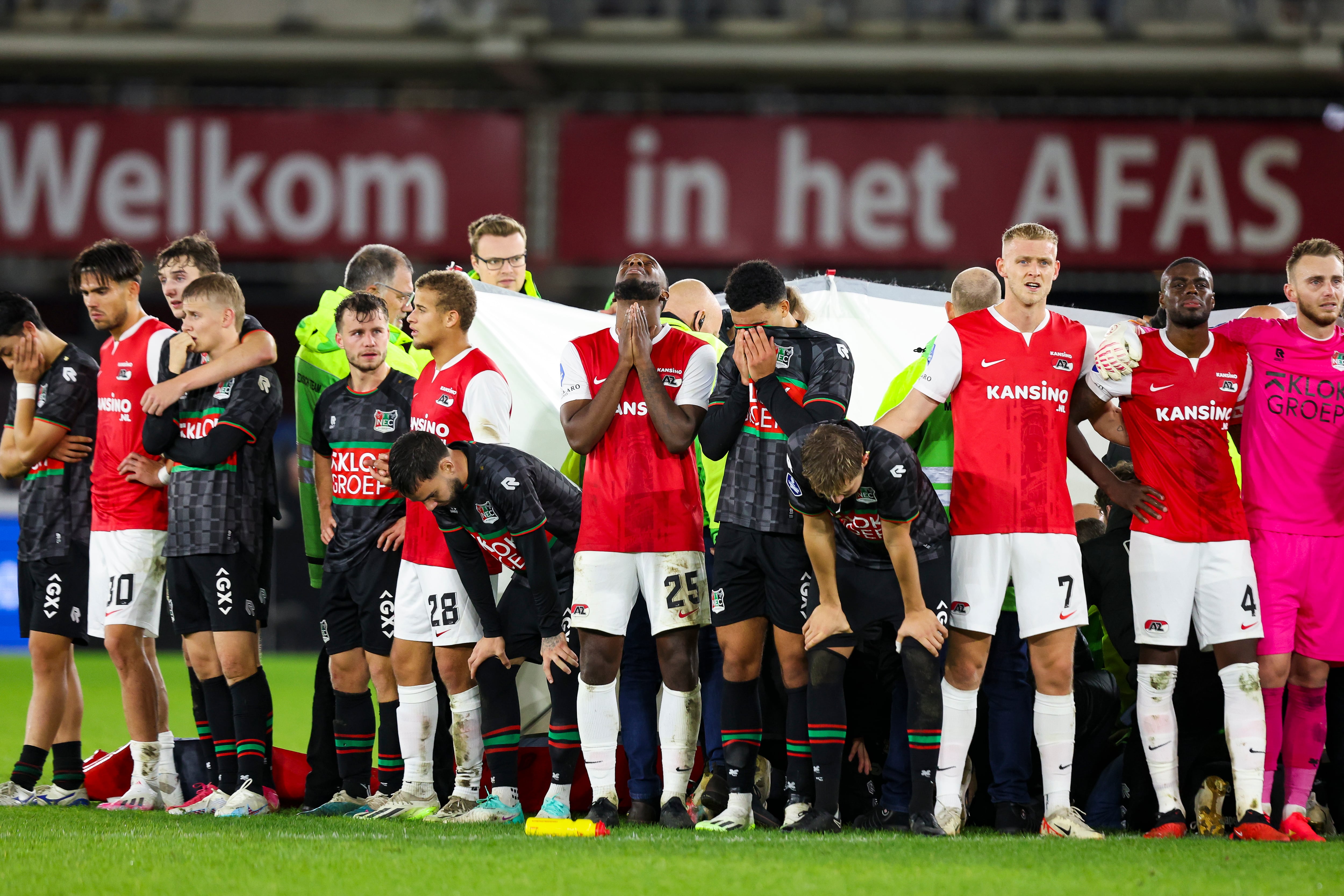 Los futbolistas del AZ y del NEC Nijmegen hacen una muralla humana mientras atienden a Bas Dost.