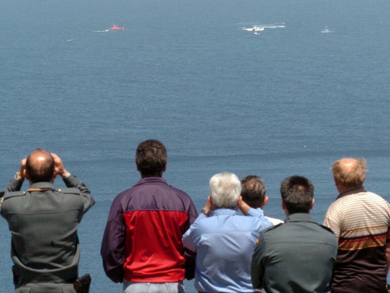 Un Guardia Civil y varios vecinos observan a las lanchas de Salvamento durante una búsqueda al sur de las Islas Sisargas