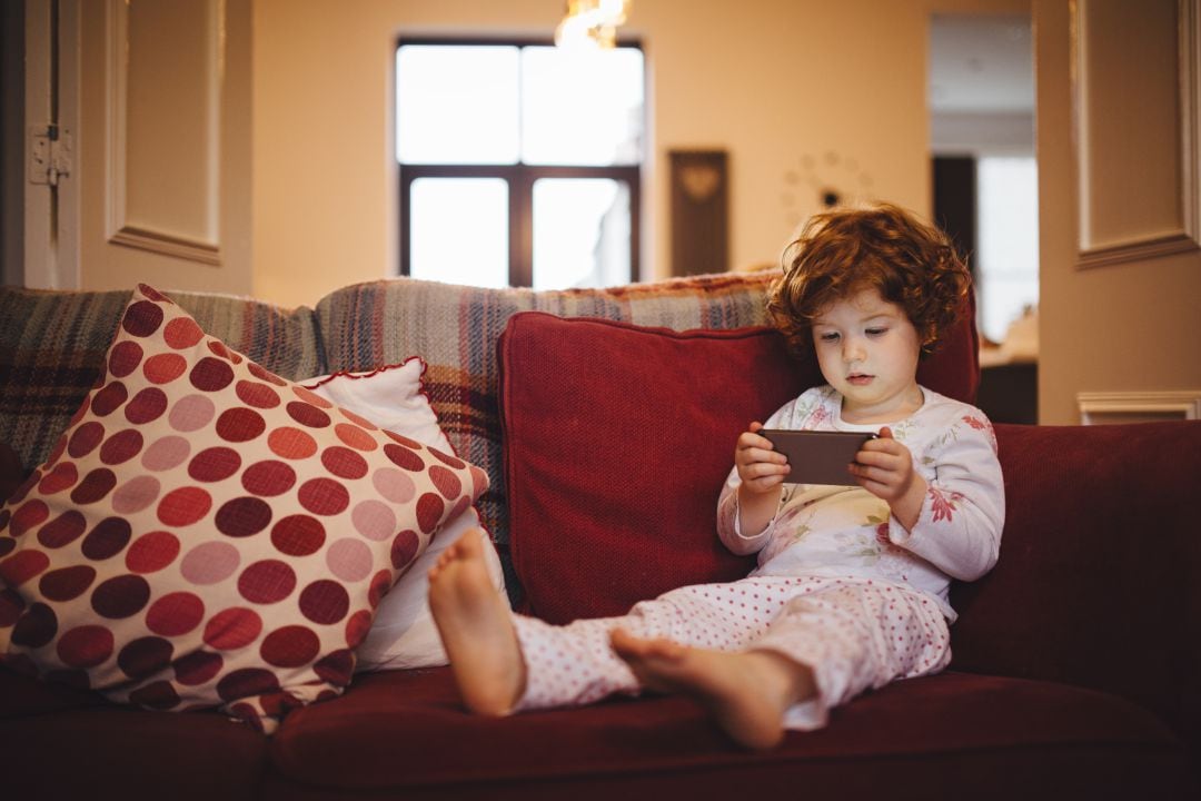 Una niñas escucha un cuento por teléfono